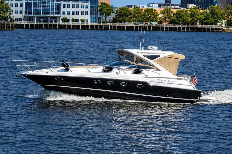 The Image of 2009 Regal Commodore 4460 yacht cruising on a sunny day near urban waterfront. - 0