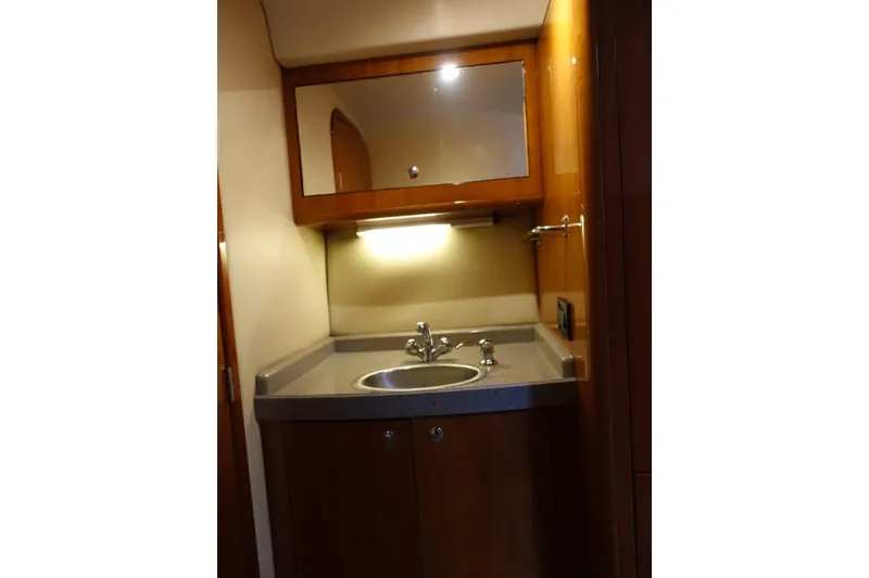 Slide: The Image of Luxurious bathroom vanity in 2009 Regal Commodore 4460 yacht, featuring wood cabinetry and modern sink. - 14