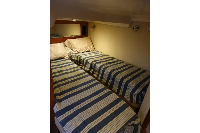 Slide: The Image of Twin beds with striped bedding in 2009 Regal Commodore 4460 cabin interior. - 17