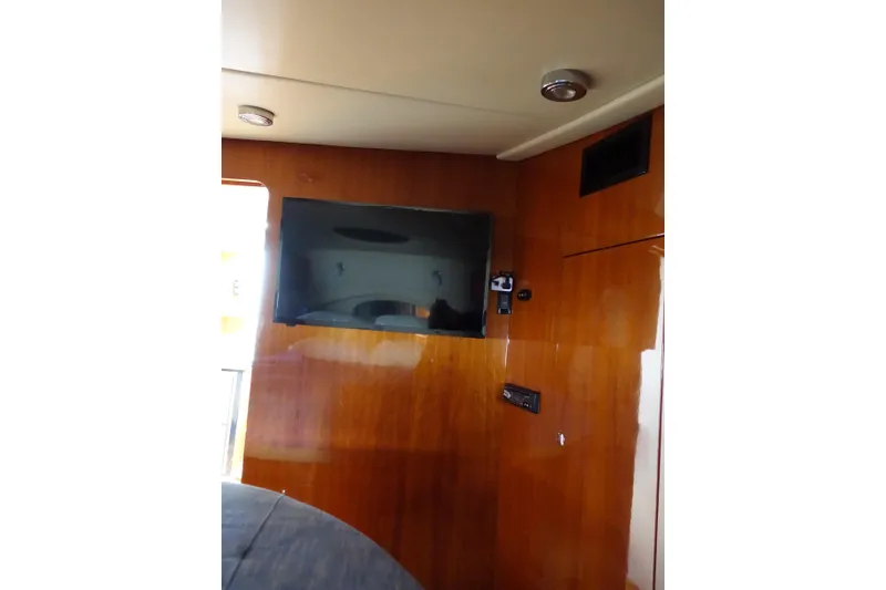 Slide: The Image of Interior of 2009 Regal Commodore 4460 yacht with mounted TV on wooden paneling. - 20