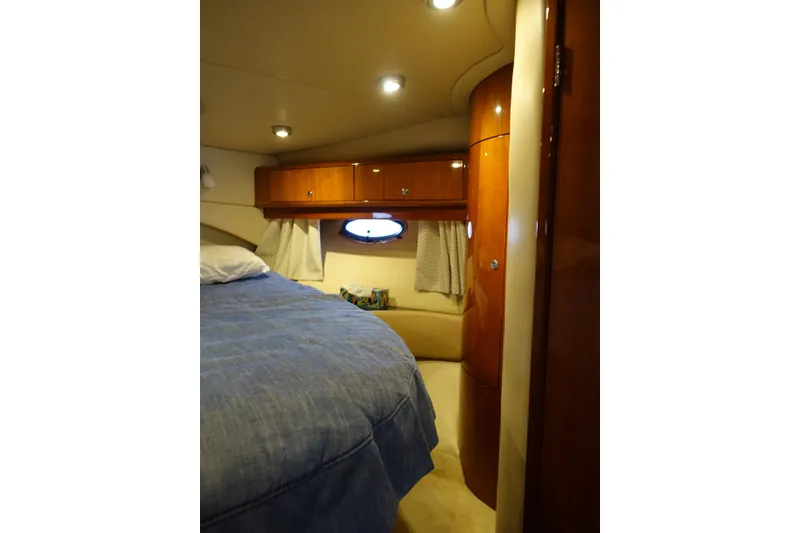 Slide: The Image of Luxurious cabin interior of 2009 Regal Commodore 4460 yacht with wood finish and cozy bedding. - 21