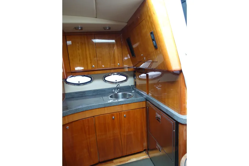 Slide: The Image of Luxurious 2009 Regal Commodore 4460 yacht kitchen with wood cabinetry and stainless steel sink. - 26