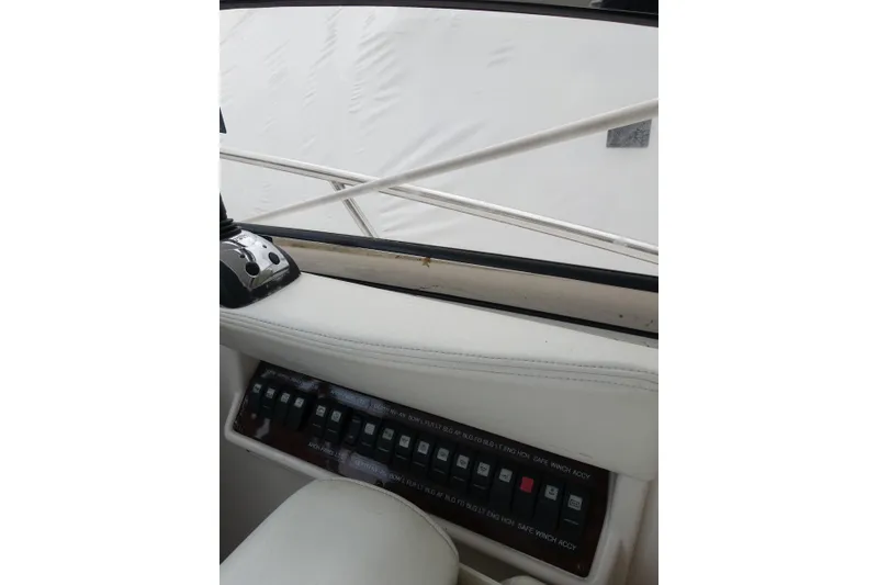 Slide: The Image of Control panel of a 2009 Regal Commodore 4460 yacht, featuring switches and a throttle. - 4