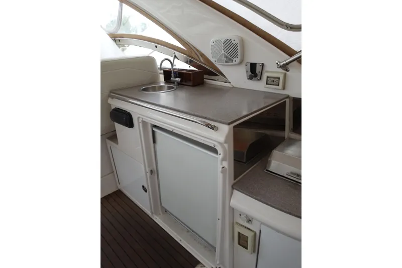 Slide: The Image of 2009 Regal Commodore 4460 yacht kitchenette with sink, countertop, and storage. - 7