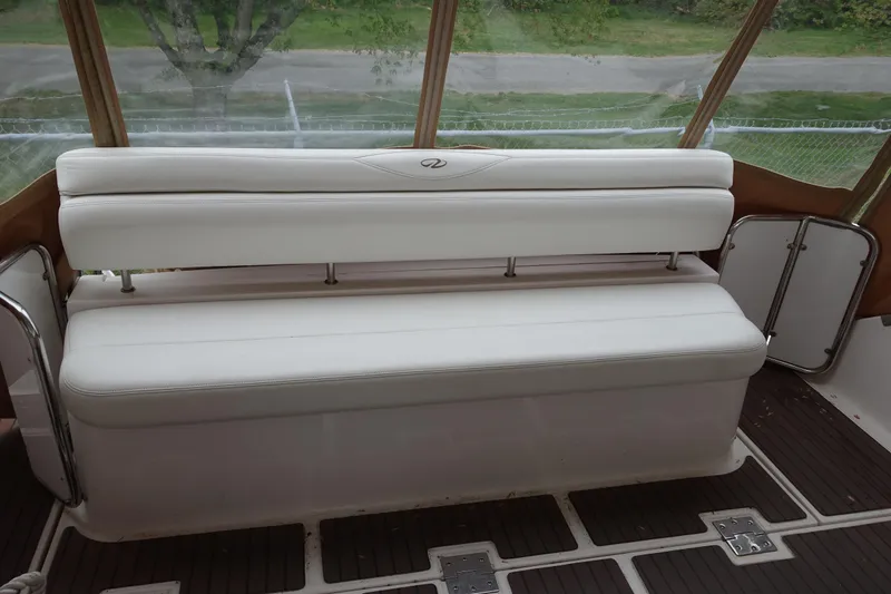 Slide: The Image of White seating on 2009 Regal Commodore 4460 boat deck, with wooden flooring. - 9