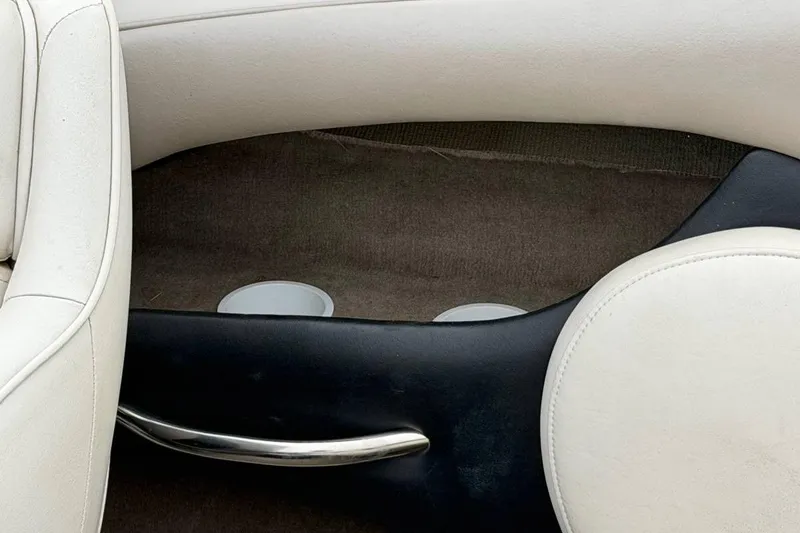 Slide: The Image of Interior of a 2001 Ebbtide Campione 200 boat with white seating and cup holders. - 6