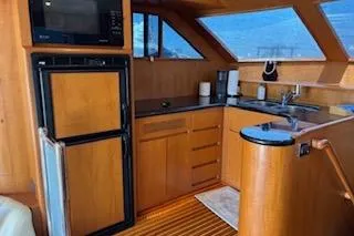Slide: The Image of 2006 Ocean Alexander 48 Sedan yacht kitchen with wood cabinetry and modern appliances. - 14