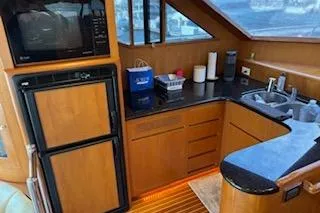 Slide: The Image of 2006 Ocean Alexander 48 Sedan yacht kitchen with wood cabinetry and modern appliances. - 16