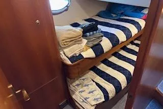 Slide: The Image of 2006 Ocean Alexander 48 Sedan cabin with bunk beds and striped bedding. - 17