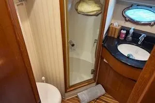 Slide: The Image of 2006 Ocean Alexander 48 Sedan bathroom with shower, sink, and wooden accents. - 22