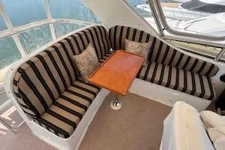 Slide: The Image of 2006 Ocean Alexander 48 Sedan interior with striped seating and wooden table. - 4