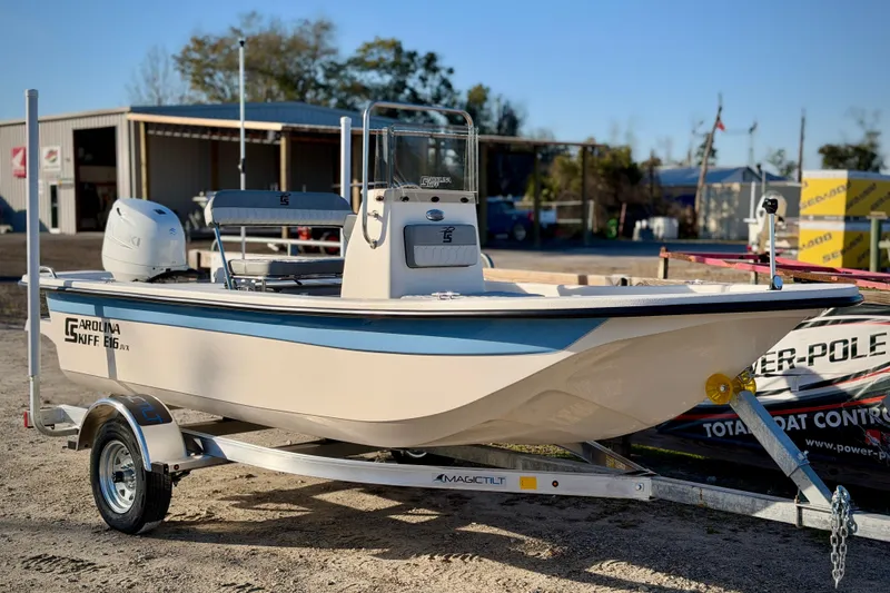 The Image of 2026 Carolina Skiff E16 JVX CC boat on trailer, parked outdoors. - 0