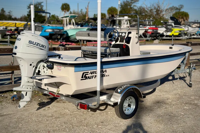 Slide: The Image of 2026 Carolina Skiff E16 JVX CC boat with Suzuki engine on trailer. - 15