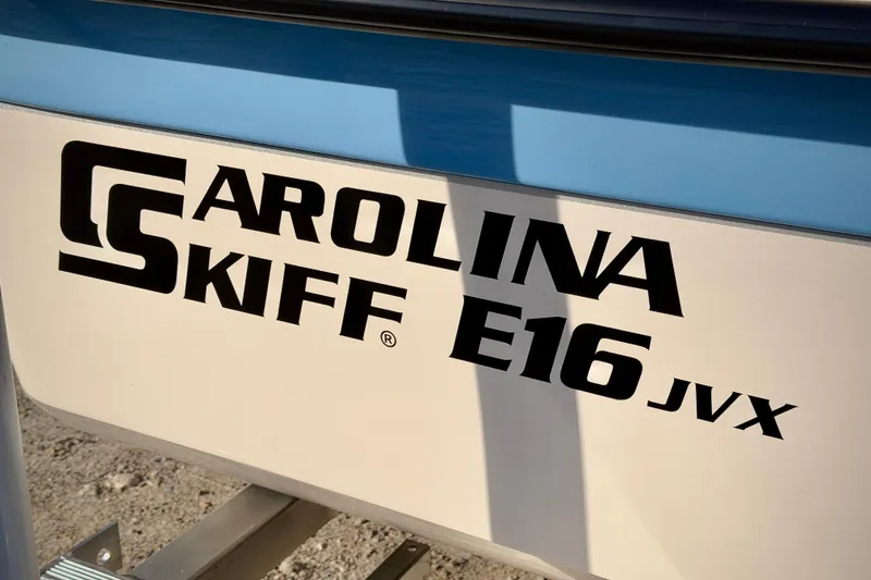 Slide: The Image of 2026 Carolina Skiff E16 JVX boat logo on hull, featuring bold black lettering. - 2