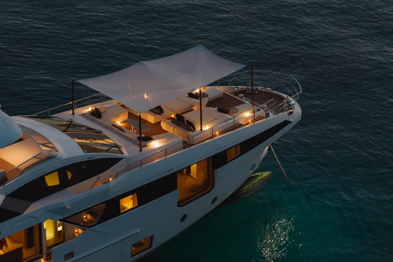 Slide: The Image of Luxurious 2023 Azimut Grande 32M yacht illuminated at dusk on serene waters. - 7