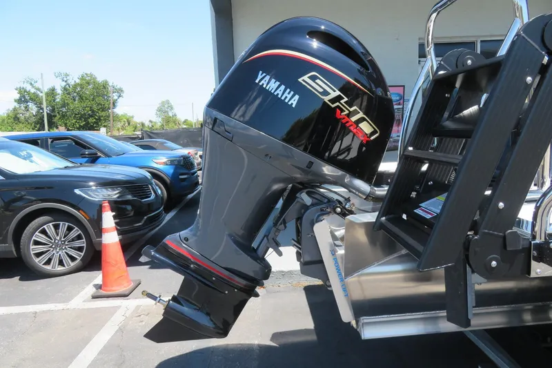 Slide: The Image of Yamaha outboard motor on 2026 Avalon Venture 85 Quad Lounge boat, parked near vehicles. - 10