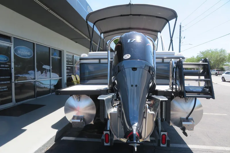 Slide: The Image of 2026 Avalon Venture 85 Quad Lounge boat with powerful outboard motor, parked outside dealership. - 12