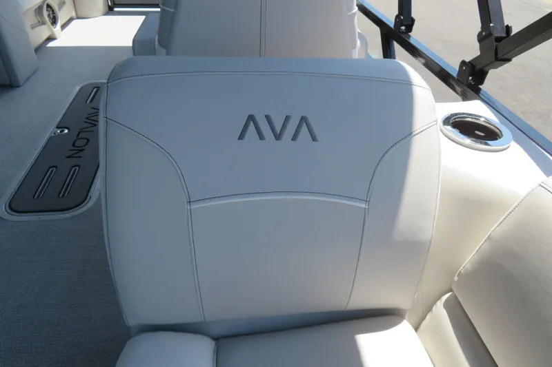 Slide: The Image of 2026 Avalon Venture 85 Quad Lounge boat interior with plush seating and cup holder. - 23