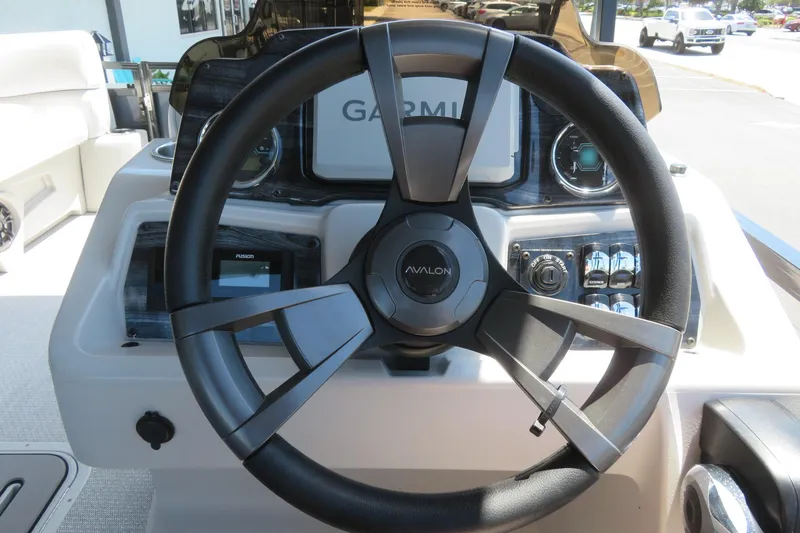 Slide: The Image of Steering wheel of 2026 Avalon Venture 85 Quad Lounge boat, featuring Garmin navigation. - 51