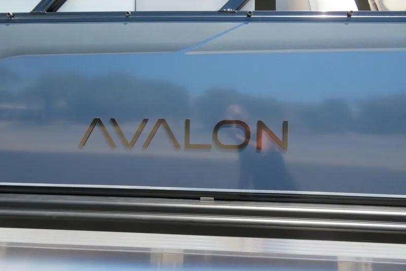 Slide: The Image of 2026 Avalon Venture 85 Quad Lounge boat logo on sleek blue surface. - 6