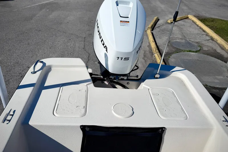 Slide: The Image of 2026 Carolina Skiff E20 JVX CC boat with Honda 115 outboard motor, parked on pavement. - 7