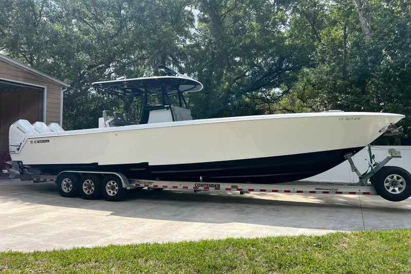 The Image of 2018 Contender 39 ST boat on trailer, parked outdoors with trees in the background. - 0
