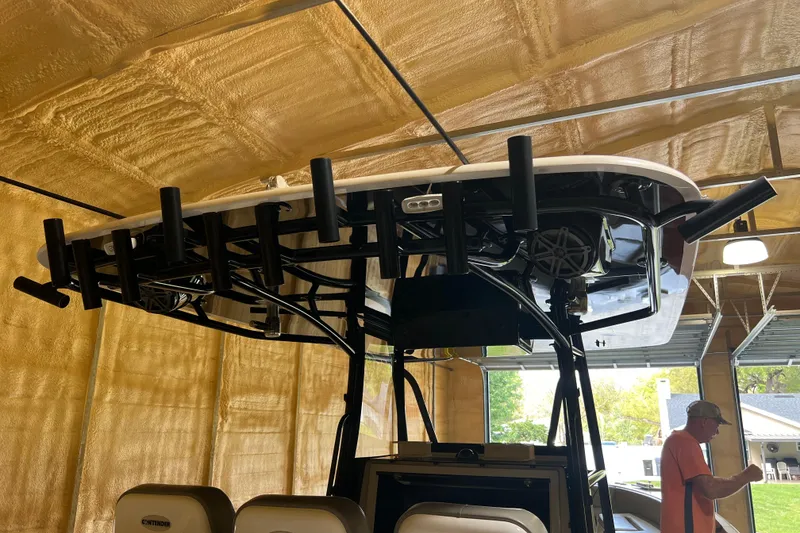 Slide: The Image of 2018 Contender 39 ST boat in a garage, featuring rod holders and speakers. - 20