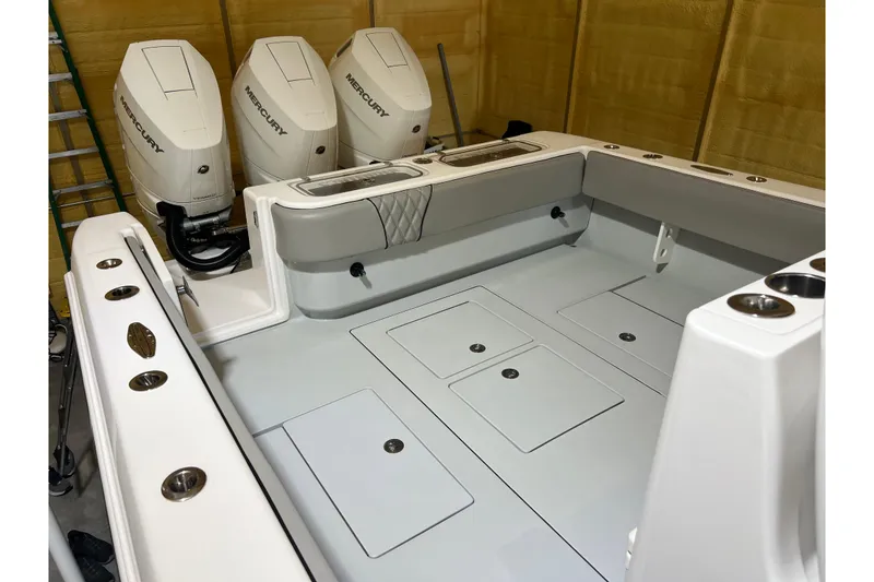 Slide: The Image of 2018 Contender 39 ST boat with triple Mercury outboard engines in a garage. - 23