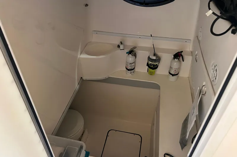 Slide: The Image of 2018 Contender 39 ST boat interior with toilet, fire extinguishers, and storage space. - 24