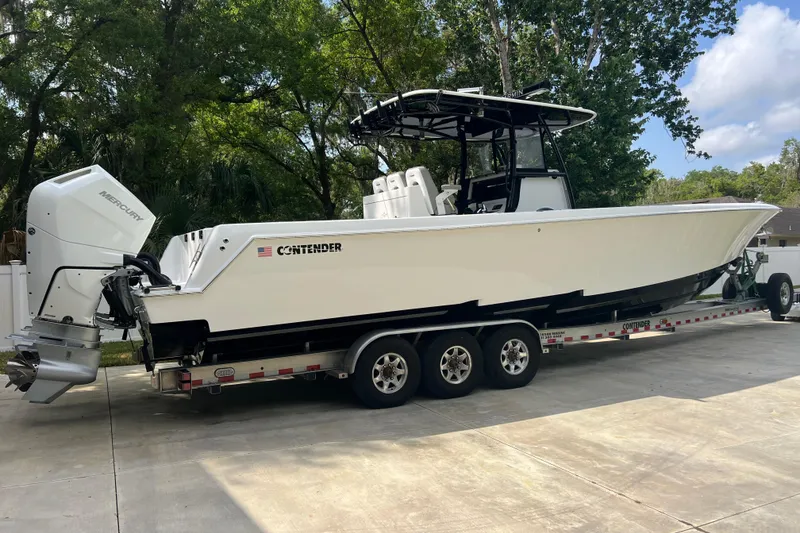 Slide: The Image of 2018 Contender 39 ST boat on trailer with Mercury engines, parked outdoors. - 3