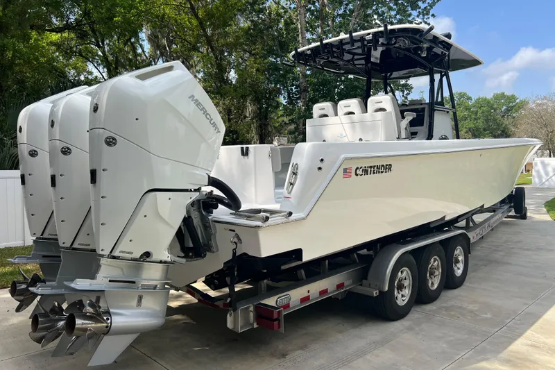 Slide: The Image of 2018 Contender 39 ST boat on trailer with triple Mercury outboard engines. - 4
