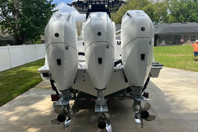 Slide: The Image of 2018 Contender 39 ST boat with triple outboard engines on a driveway. - 5