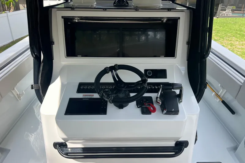 Slide: The Image of 2018 Contender 39 ST boat helm with steering wheel, controls, and electronic displays. - 9