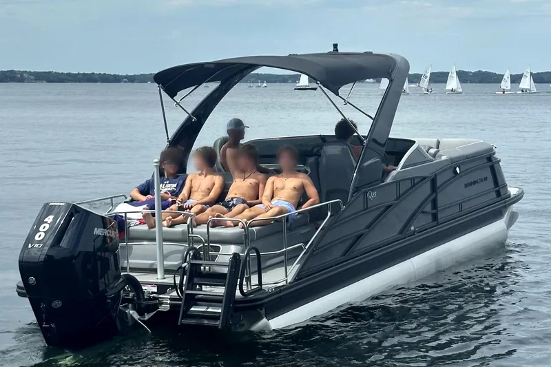 Slide: The Image of 2024 Bennington 25 QSBWA pontoon boat with passengers relaxing on a lake. - 15