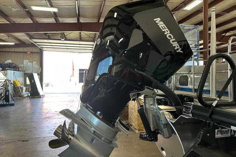 Slide: The Image of 2024 Bennington 25 QSBWA with Mercury outboard motor in a workshop setting. - 19