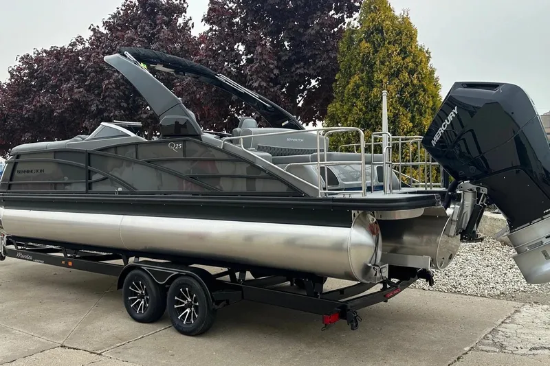 Slide: The Image of 2024 Bennington 25 QSBWA pontoon boat on trailer with Mercury outboard motor. - 26