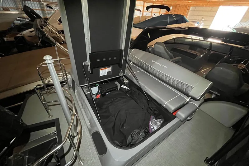 Slide: The Image of 2024 Bennington 25 QSBWA boat interior with open storage compartment and seating. - 30