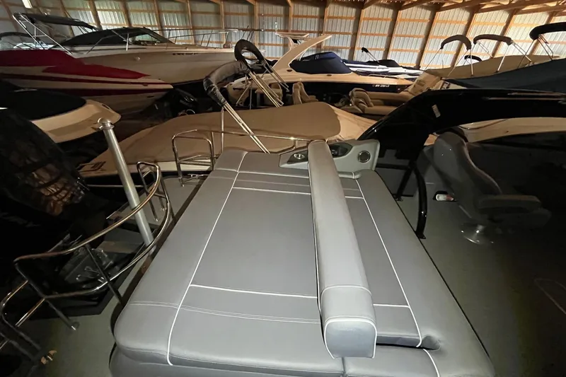Slide: The Image of 2024 Bennington 25 QSBWA pontoon boat in storage, featuring sleek seating and modern design. - 33