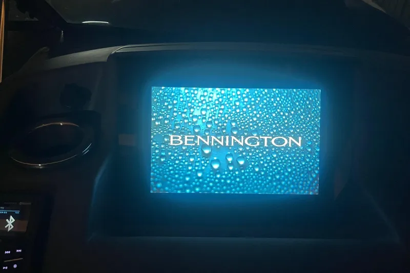 Slide: The Image of Dashboard display of 2024 Bennington 25 QSBWA with logo and water droplets. - 43
