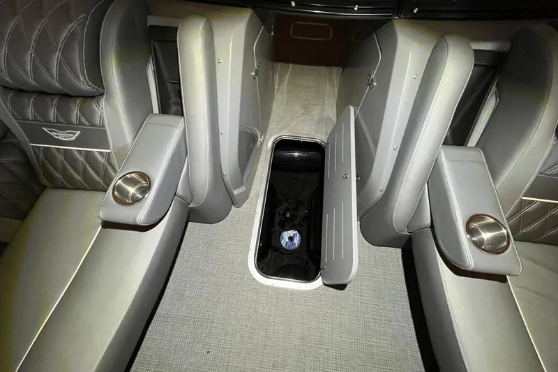 Slide: The Image of 2024 Bennington 25 QSBWA interior with open storage compartment and luxurious seating. - 47
