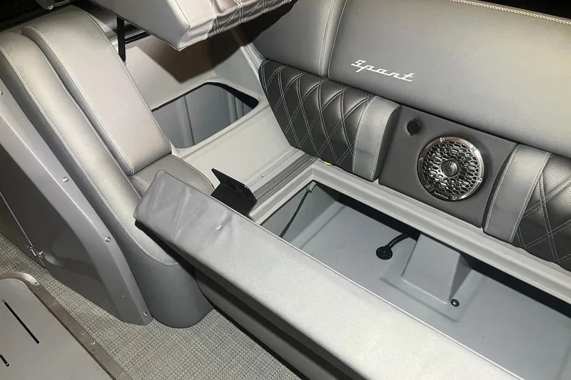 Slide: The Image of 2024 Bennington 25 QSBWA boat interior with storage compartments and speaker system. - 52