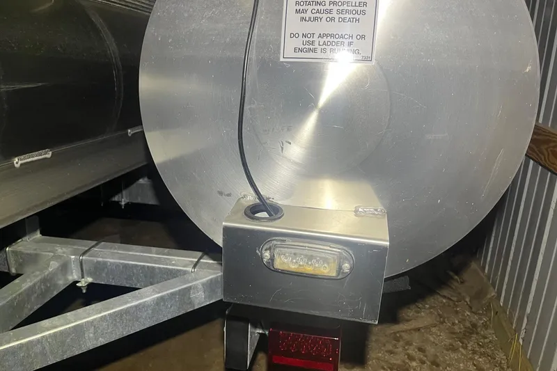 Slide: The Image of Rear view of a 2024 Bennington 25 QSBWA pontoon boat with safety warning label. - 58