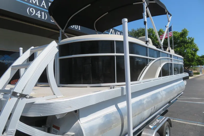 Slide: The Image of 2018 Bennington 23 SSRXP pontoon boat with canopy on trailer, parked outdoors. - 17