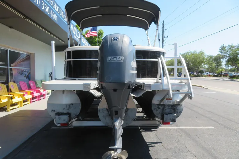 Slide: The Image of 2018 Bennington 23 SSRXP pontoon boat with Yamaha 150 outboard motor, parked outside dealership. - 18