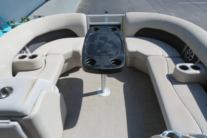 Slide: The Image of 2018 Bennington 23 SSRXP boat interior with beige seating and black table. - 21