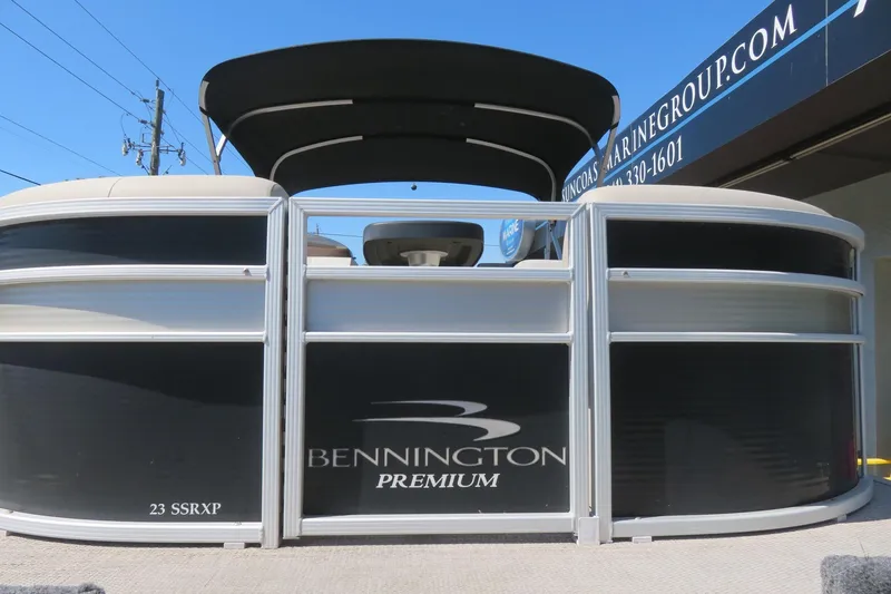 Slide: The Image of 2018 Bennington 23 SSRXP pontoon boat with black and silver design, displayed outdoors. - 7