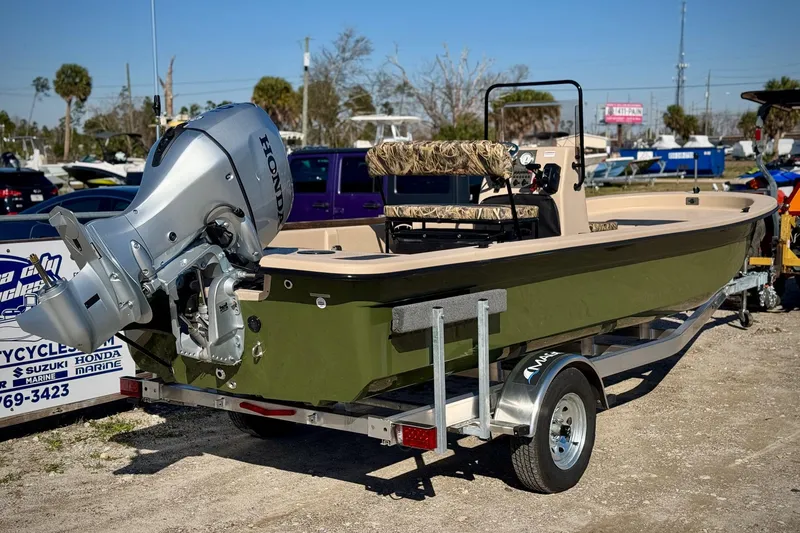 Slide: The Image of 2025 Carolina Skiff E20 JVX CC SPORTSMAN EDITION boat on trailer with Honda outboard motor. - 2