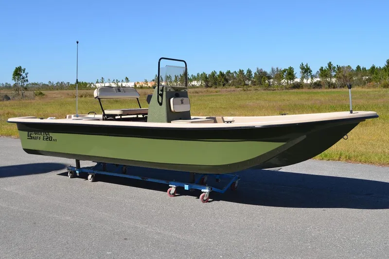 Slide: The Image of Manufacturer Provided Image: 2026 Carolina Skiff E20 JVX CC boat on trailer, green hull, outdoor setting. - 23