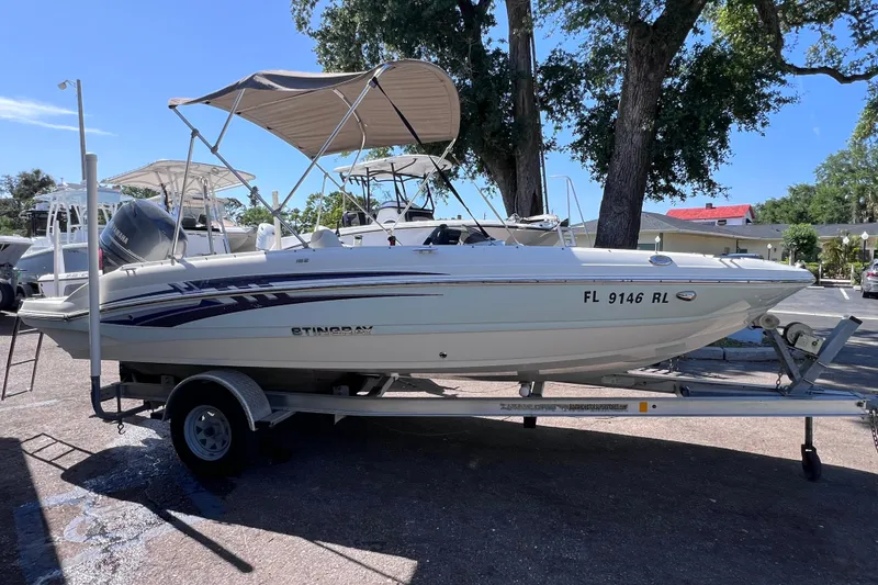 The Image of 2017 Stingray 182 SC boat on trailer with canopy, parked outdoors. - 0