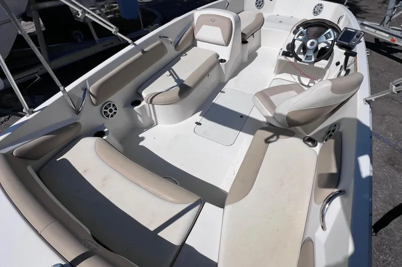 Slide: The Image of 2017 Stingray 182 SC boat interior with beige seating and steering console. - 10